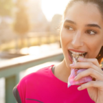 Sporty woman eating energy bar